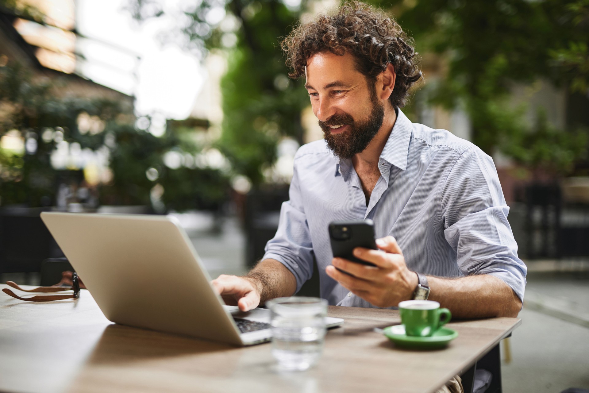 Freelancer working remotely from a cafe using laptop and smartphone