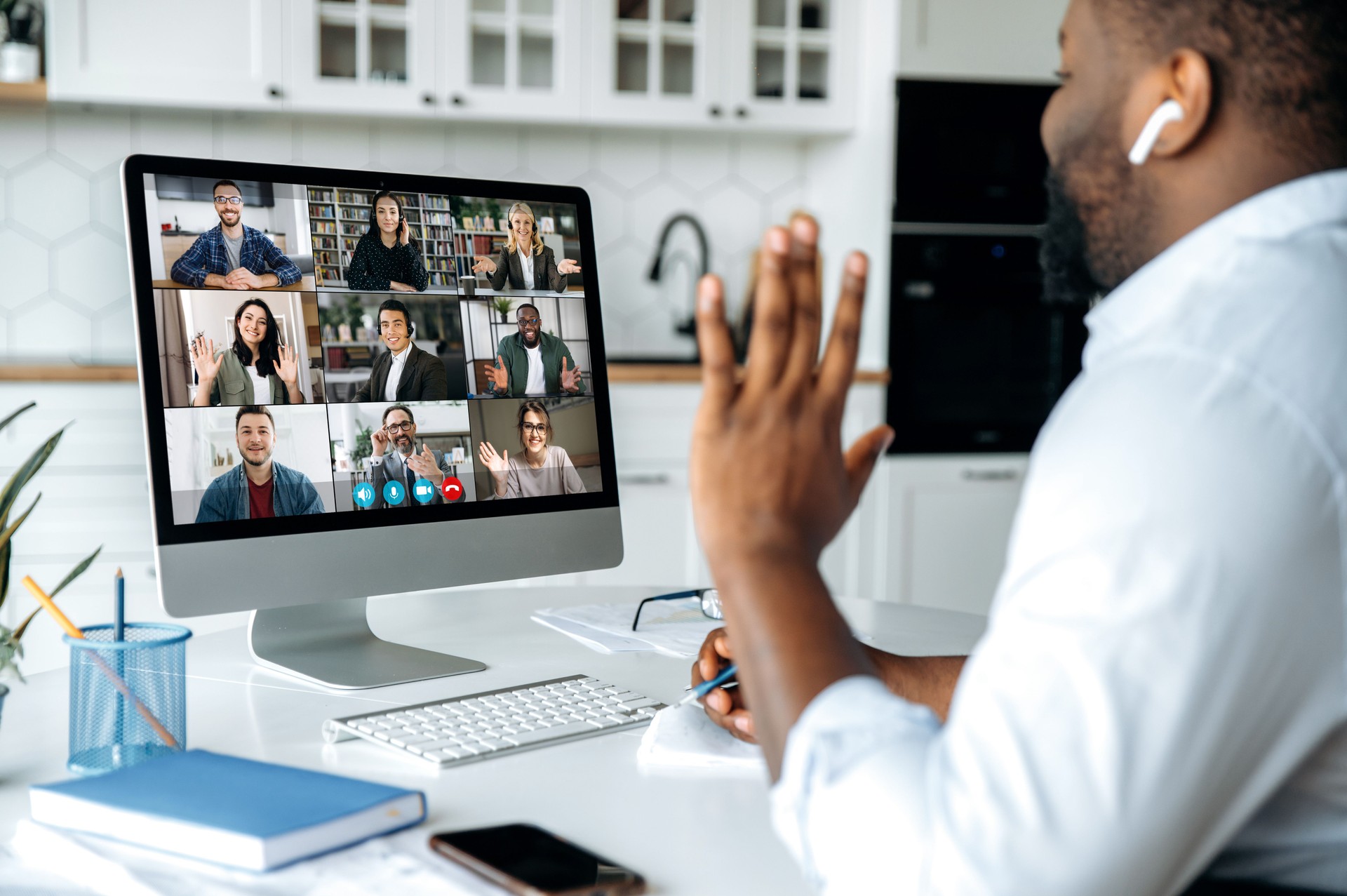 Videoanruf, Online-Konferenz. Über Schulter Blick auf afrikanischen amerikanischen Mann am Computer-Bildschirm mit multinationalen Gruppe von erfolgreichen Geschäftsleuten, virtuelle Business-Meeting, Arbeit von zu Hause Konzept