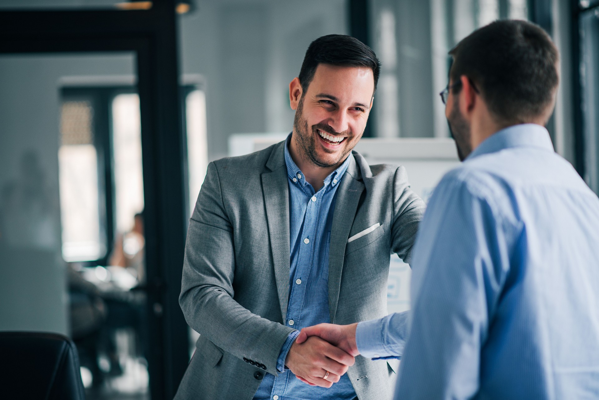 Porträt der fröhliche junge Manager Handshake mit neuer Mitarbeiter.