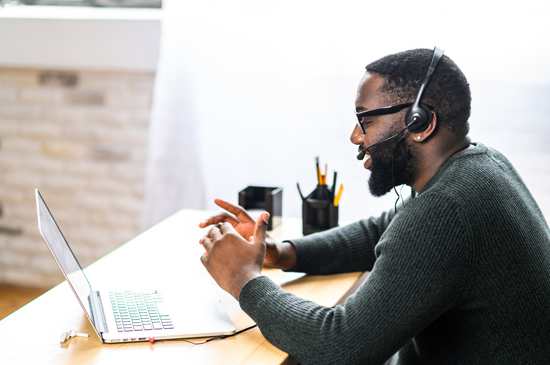 Afroamerikanischer Kerl mit Headset mit Laptop