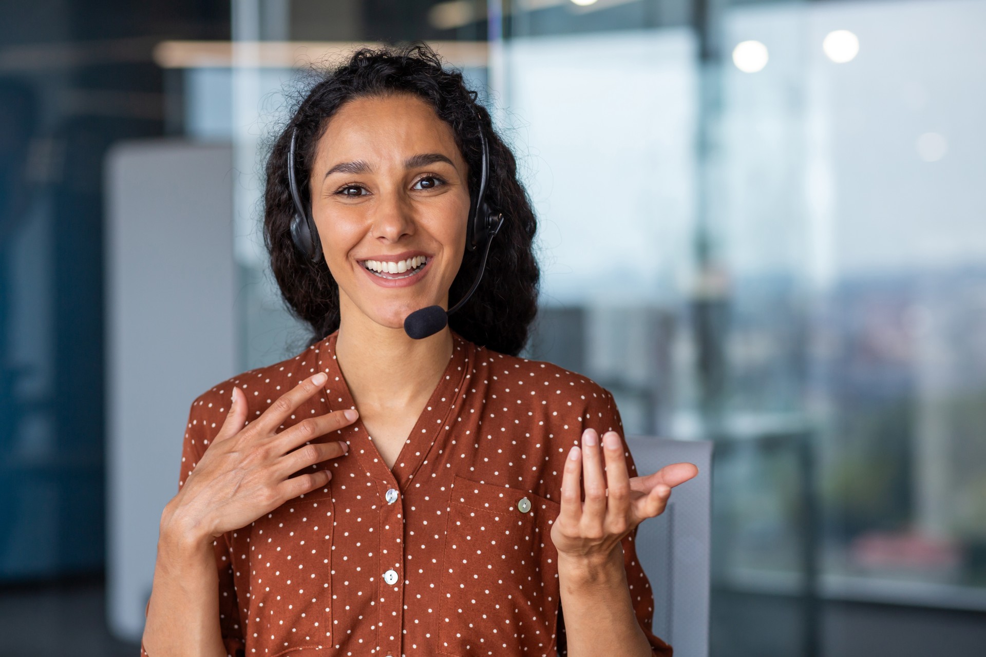 Web camera view, female worker with headset phone talking consults clients remotely, business woman looking at camera smiling