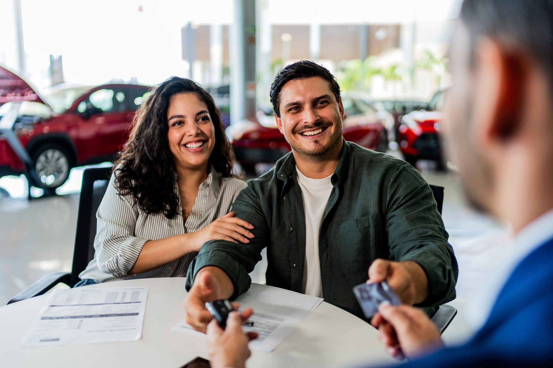 Paar unterschreibt den Erhalt des Autoschlüssels im Autohaus